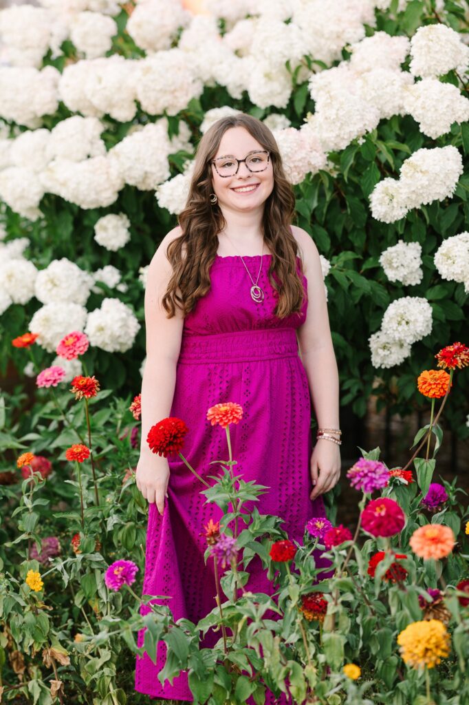 Senior girl standing in front of white hydrangeas in downtown Holland