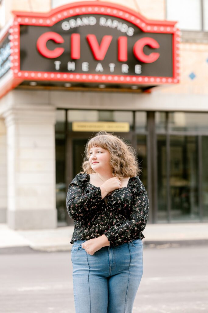 High school senior girl smiling under the Civic Theatre marquee in downtown Grand Rapids