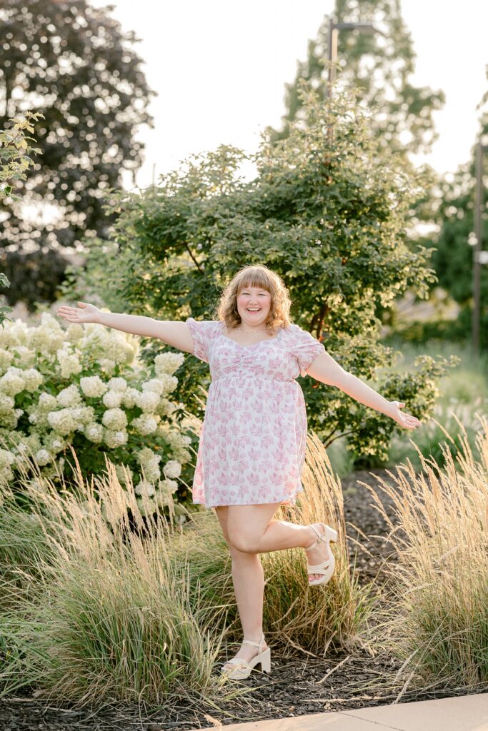Senior girl twirling in a city garden during her Grand Rapids senior photos