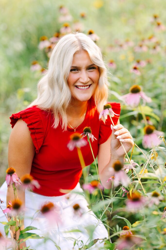 Senior girl smiling in a field of wildflowers at Grand Ravines near Grand Rapids