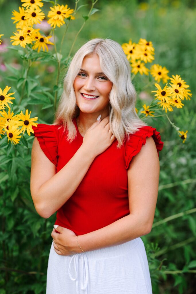 Senior portrait in yellow summer wildflowers at Grand Ravines
