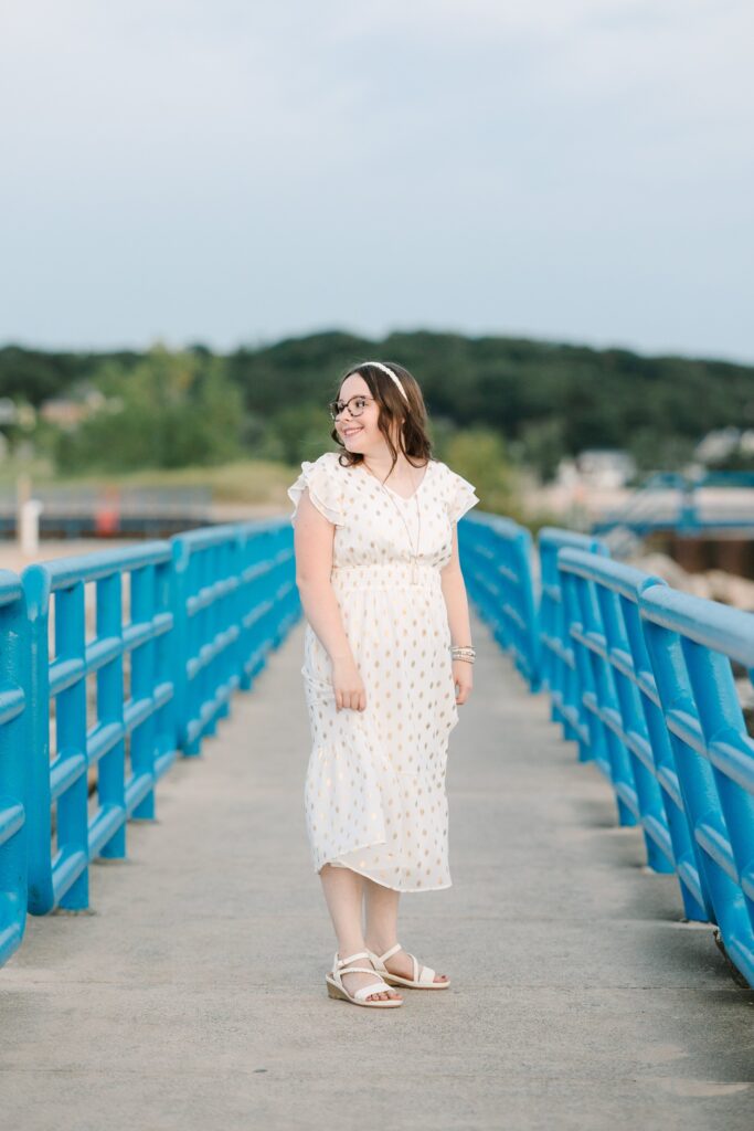 Senior portrait on the pier with blue railings at Holland State Park