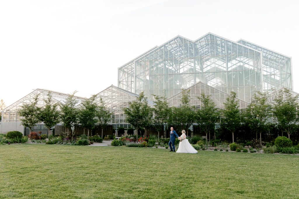 Bride and groom at sunset in front of the conservatory at Frederik Meijer Gardens