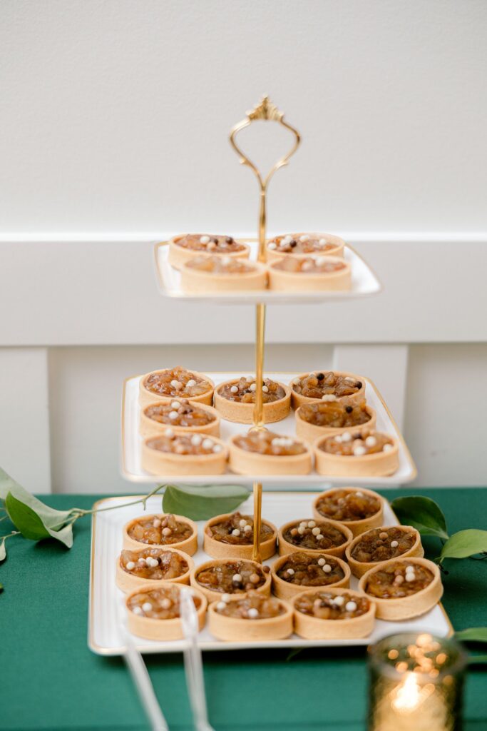 Tiered dessert stand of tarts on the green dessert table