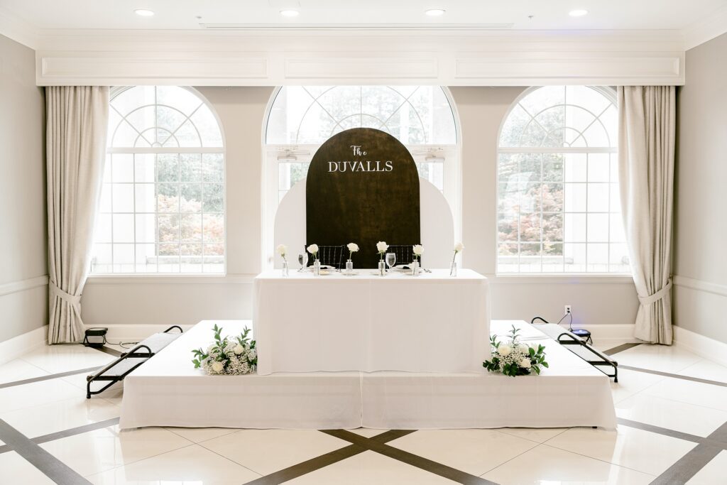 Sweetheart table with a black arch sign in the ballroom