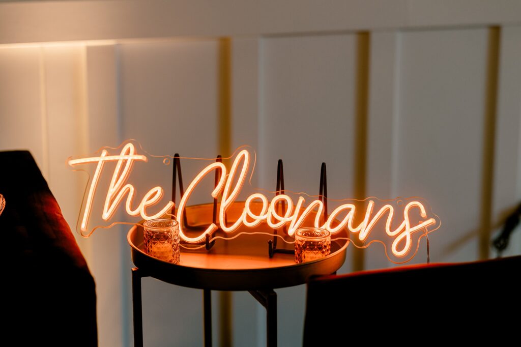 Warm neon sign reading The Cloonans at the reception