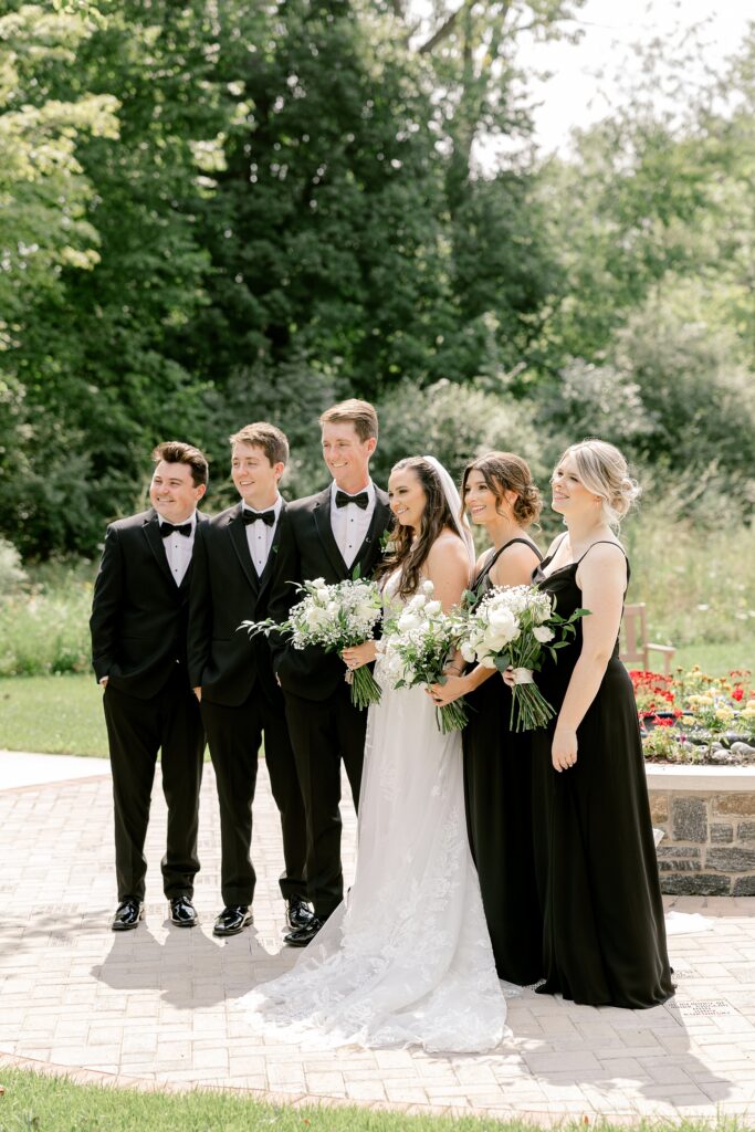 Wedding party in black tuxedos and black dresses outside the church
