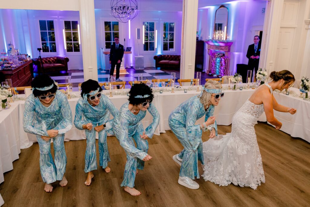 Mom of the bride and her friends in matching outfits and sunglasses dancing to Dancing Queen