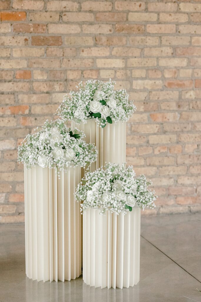 White baby's breath arrangements on pillar stands for the ceremony