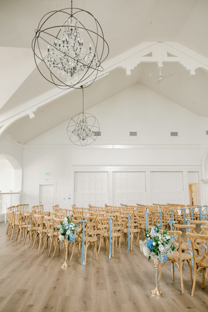 Ceremony setup with wooden chairs inside the white chapel at The Broadway Avenue